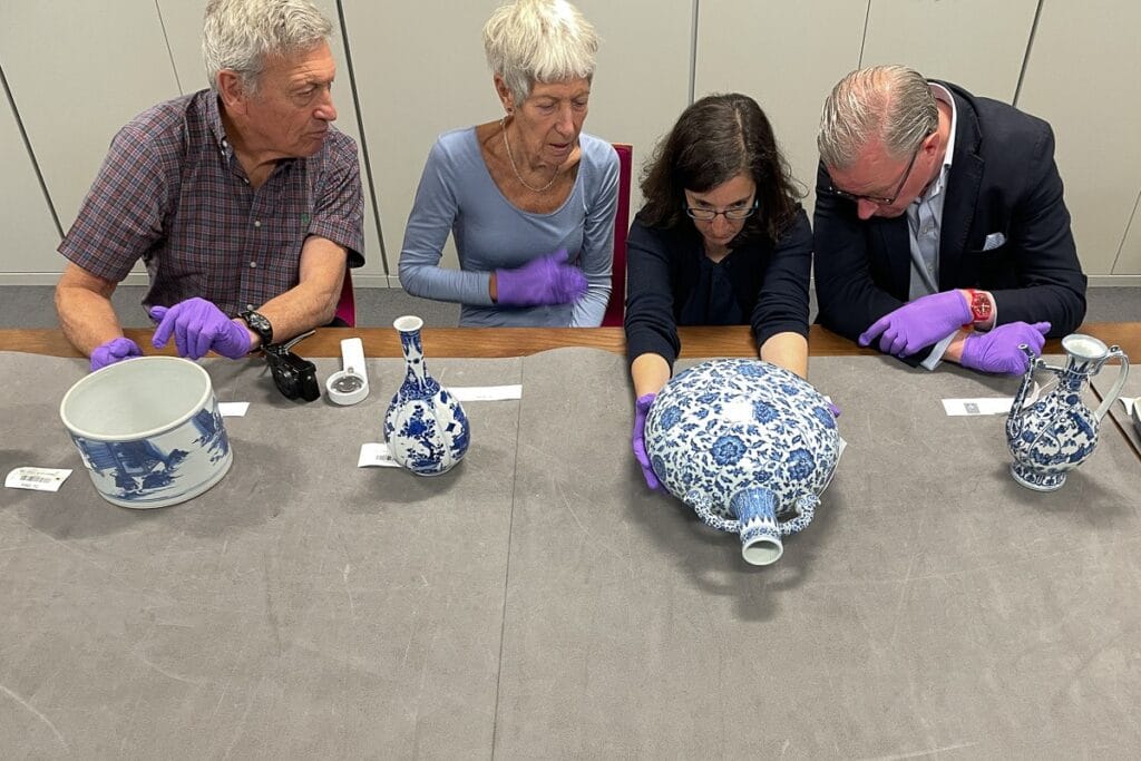 Four OCS Handling Session attendees sitting at a table holding ceramics
